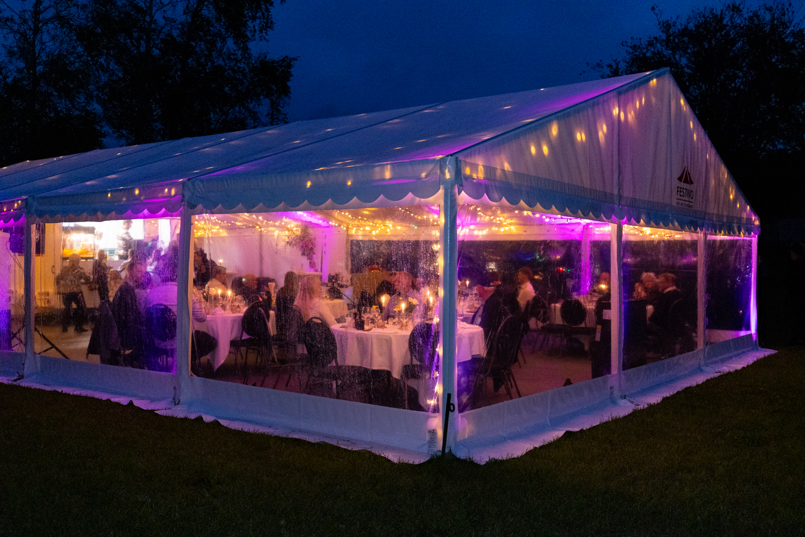 Eight shirts arranged on table in black, olive, grey, blue, white, red, mustard, and green.