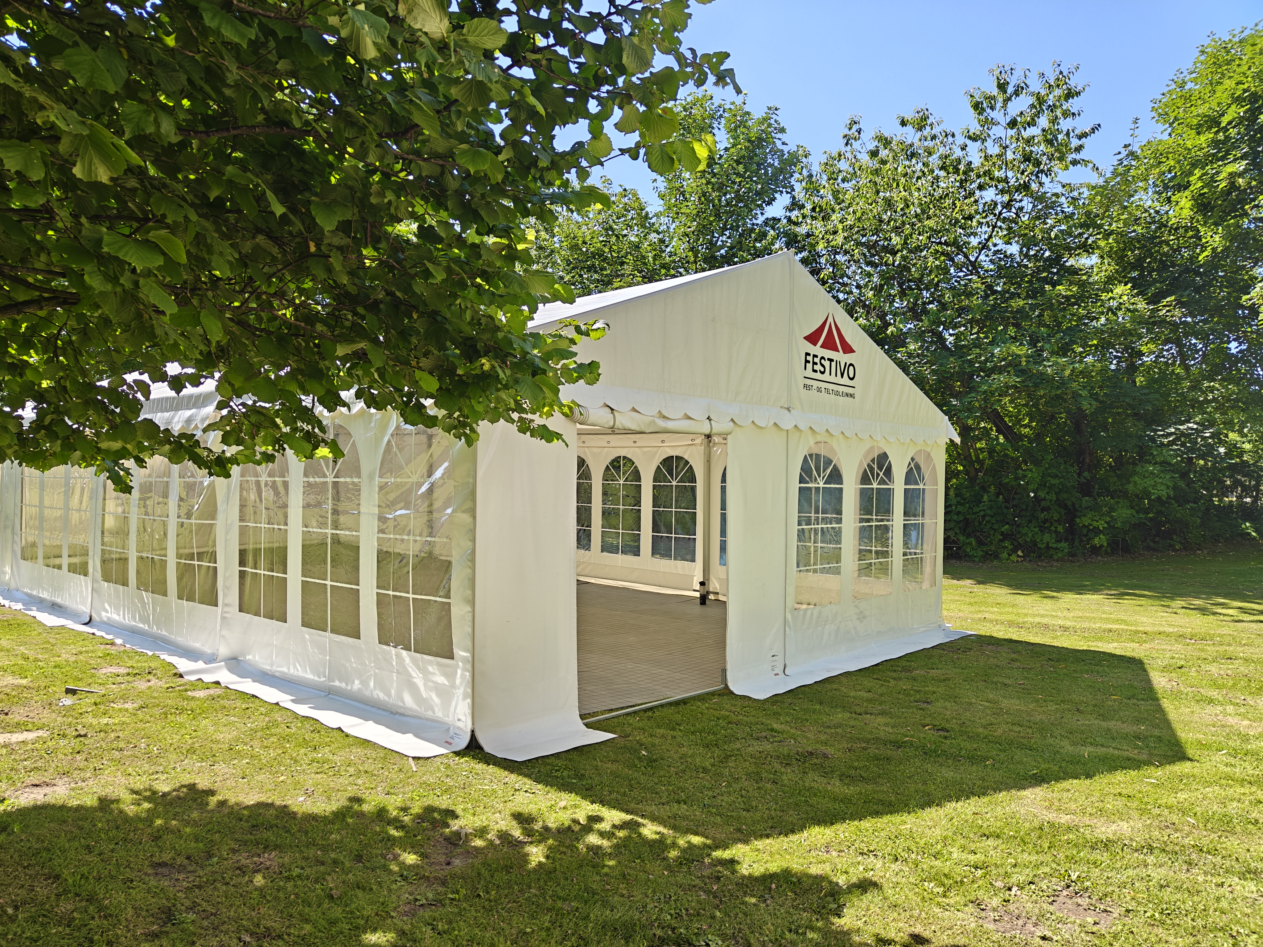 Eight shirts arranged on table in black, olive, grey, blue, white, red, mustard, and green.