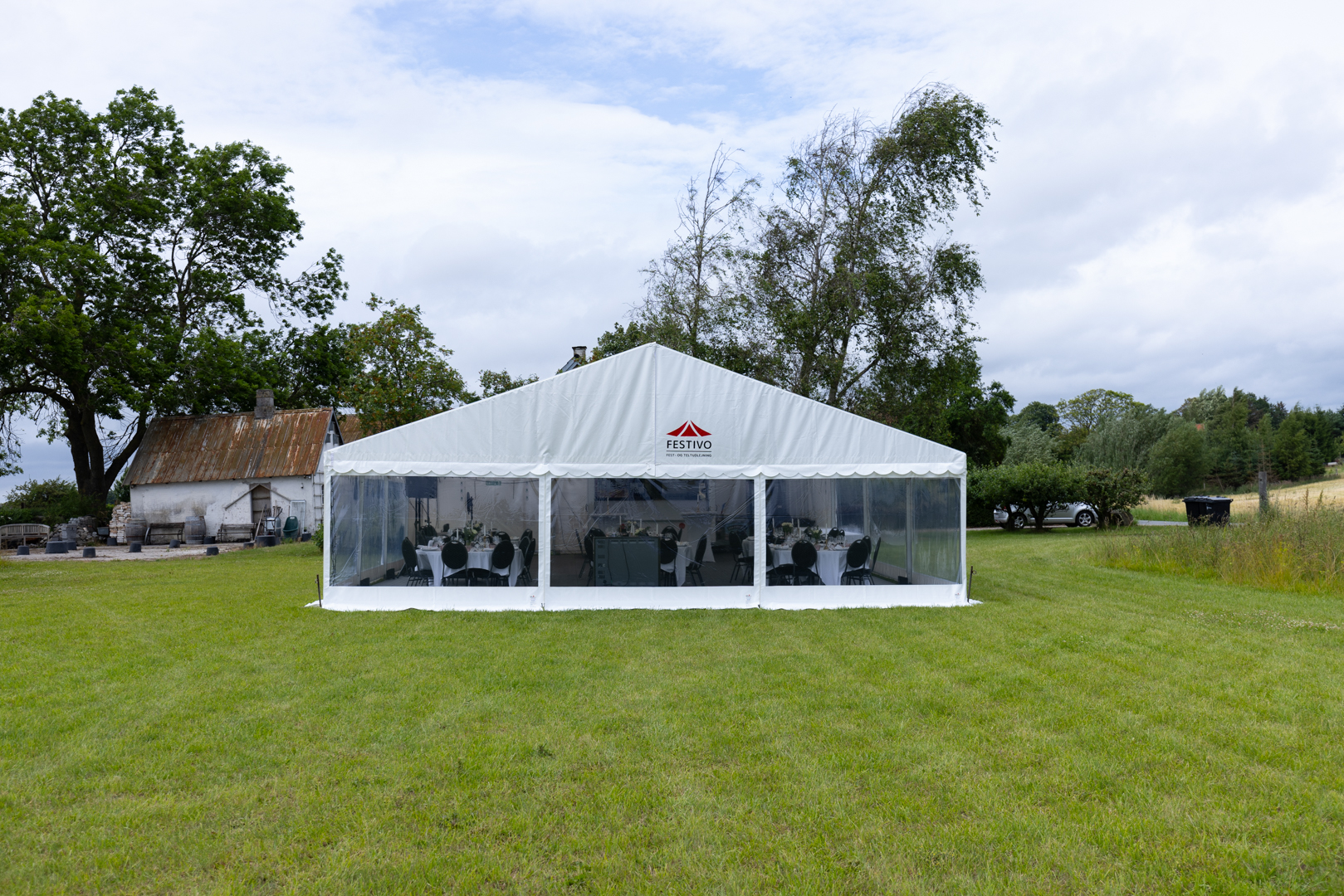 Eight shirts arranged on table in black, olive, grey, blue, white, red, mustard, and green.